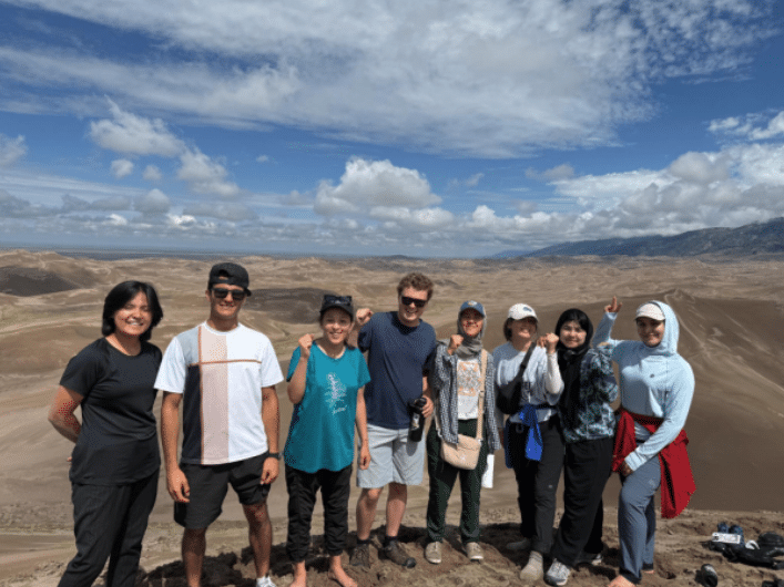 A group of ASRF volunteers and students standing together outdoors on a desert hillside