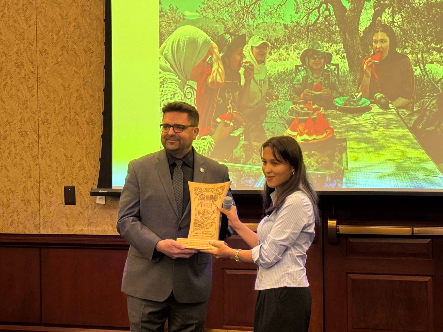 An ASRF student presenting an engraved award to Chief of Staff Mark Dreiling