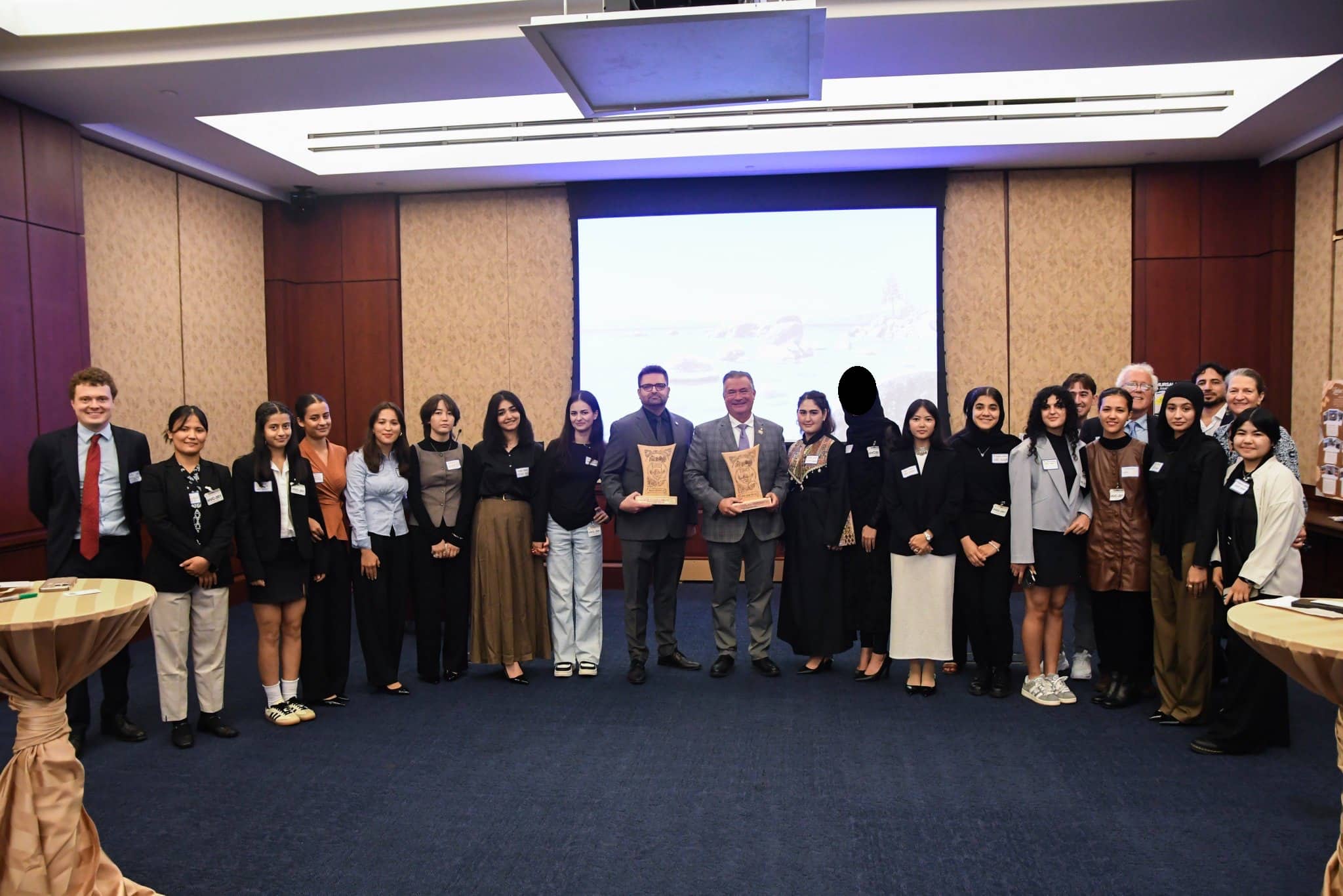 Congressman Don Bacon standing with a large group of ASRF students and guests holding award plaques at the Afghan Women’s Education reception