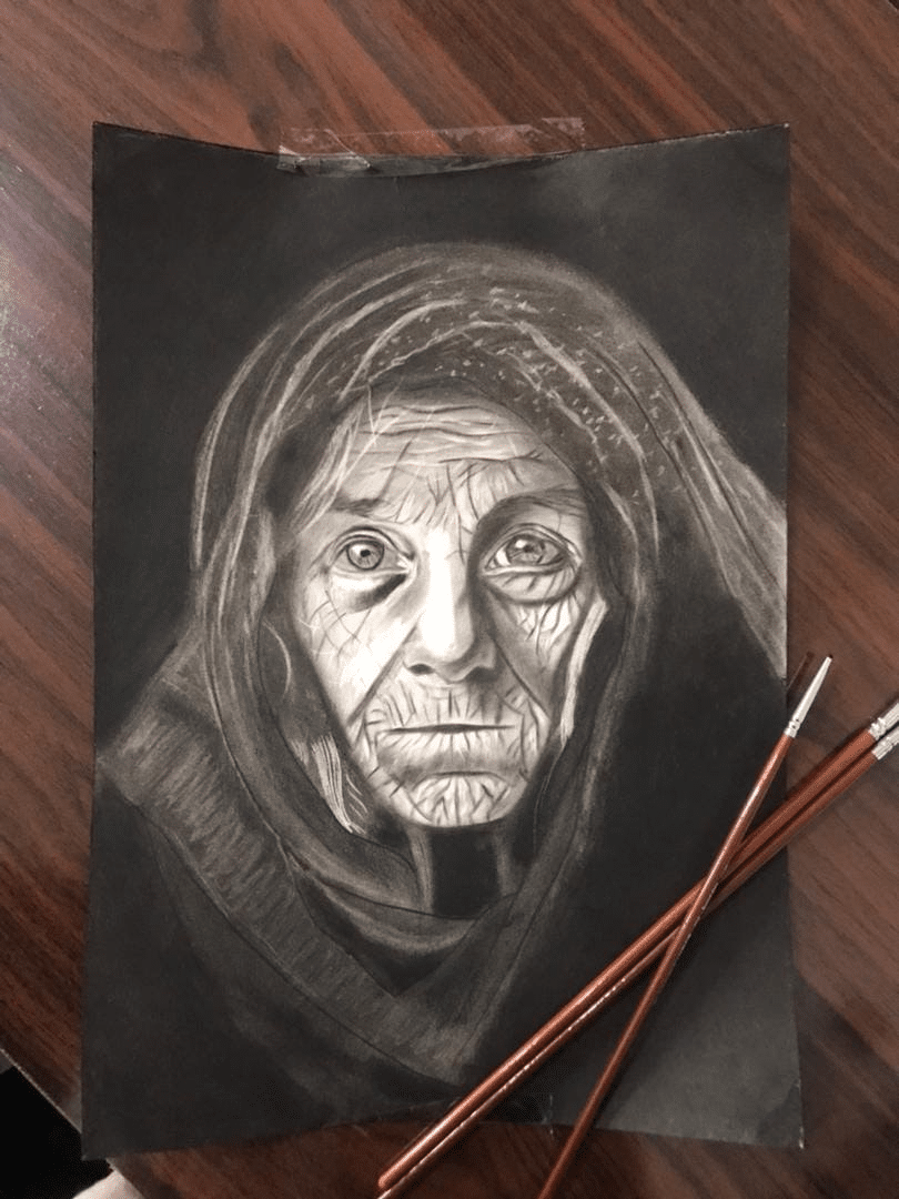 Charcoal drawing of an elderly woman’s deeply lined face framed by a dark headscarf