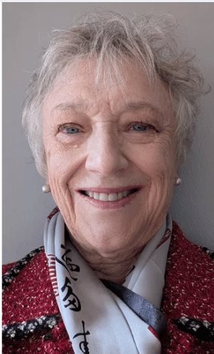 Portrait of Martha Baker smiling, wearing a patterned scarf